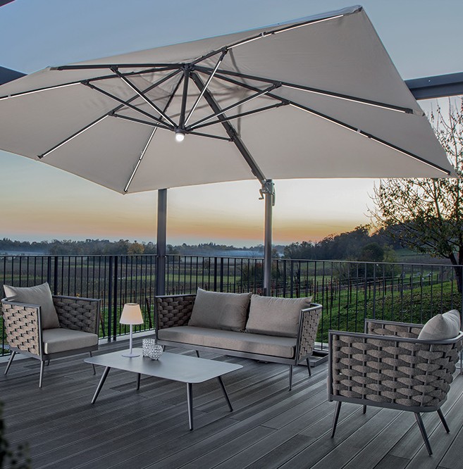 Grattoni NIZZA outdoor living room set - consisting of a two-seater sofa, two armchairs and a coffee table, set on a terrace with a parasol
