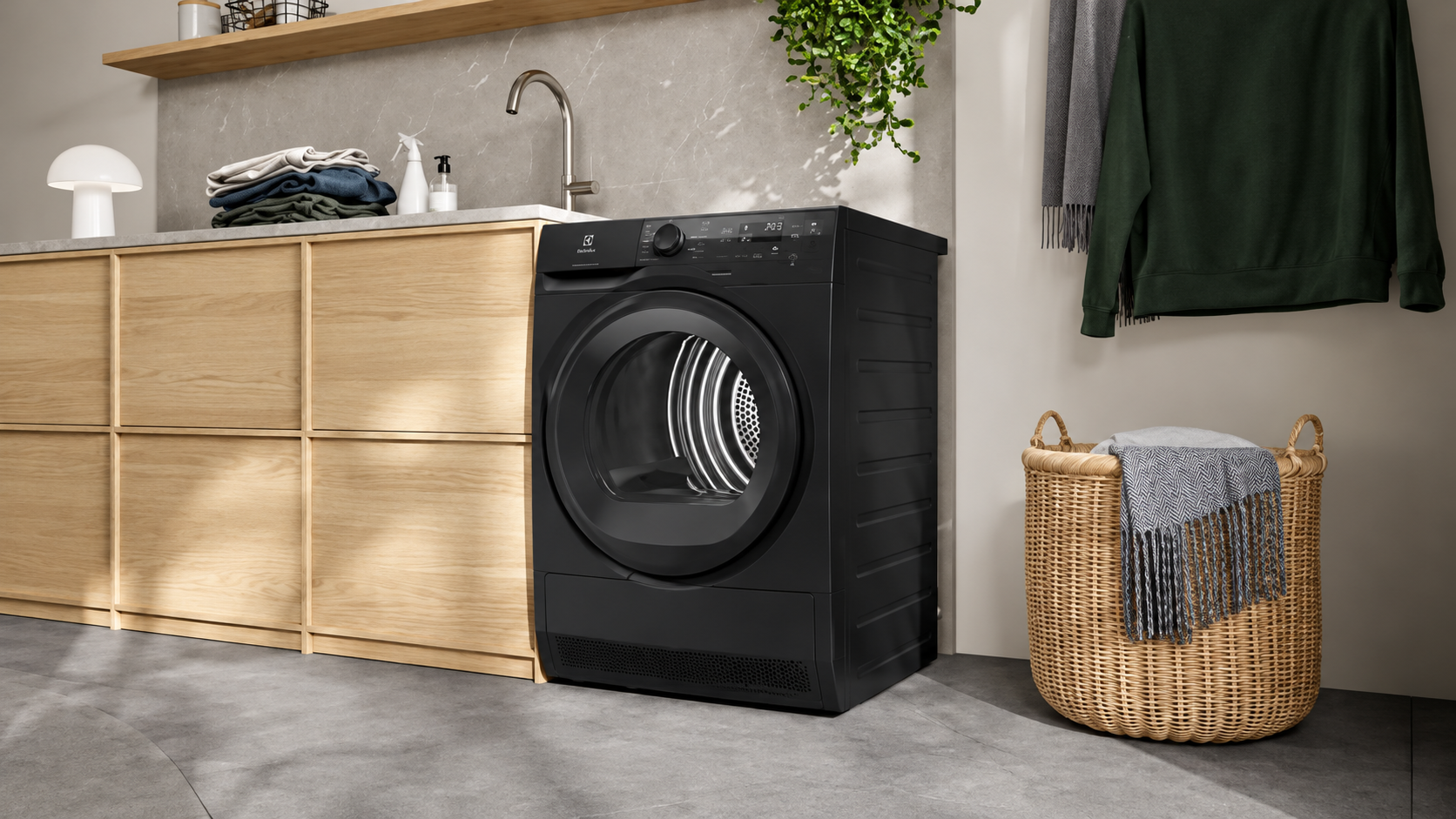 Asciugatrice Electrolux EW7H49B Serie 700 DelicateCare a pompa di calore da 9 kg, classe energetica C, colore nero, ambientata in una lavanderia moderna con mobili in legno.